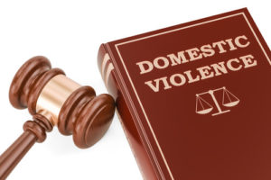 Gavil To The Left Of A Book Titled Domestic Violence On A Plain White Background