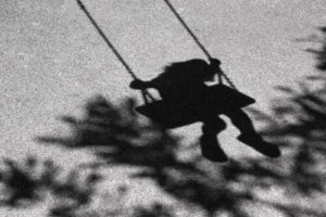 Shadow On The Ground Of A Female Child On A Swing