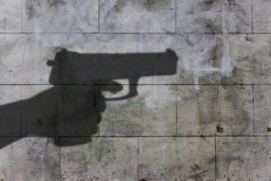 Shadow On A Wall Of A Firearm Being Pointed