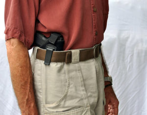 White Male In Red Button-Down Shirt And Khakis With Partially Exposed Firearm Tucked Into Waistband