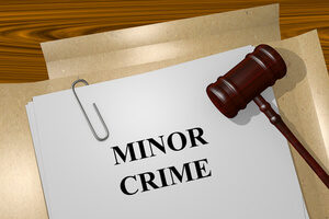 Open Manila Folder Containing Paperclipped Case Files Titled Minor Crime Next to Gavel